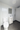 Bathroom with white toilet, sink, and mirror on a tiled floor.