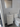 Bathroom with white vanity, sink, and toilet against a tiled wall.